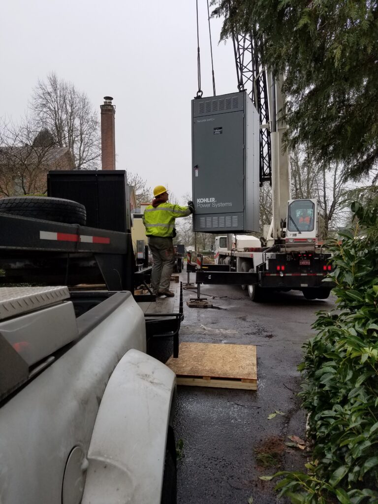 A kohler ATs being lowered by a crane for commercial backup power