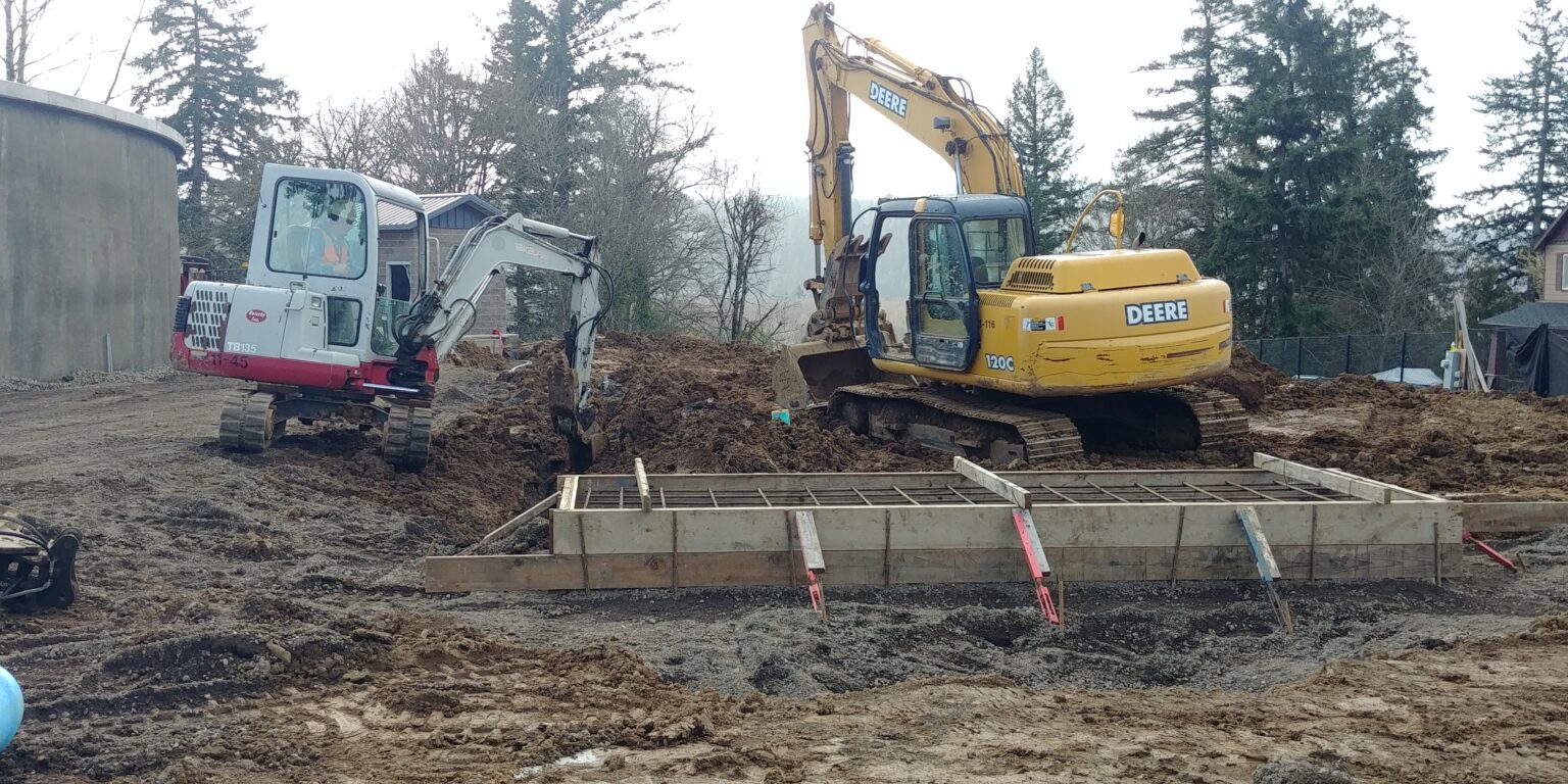 Two excavators preparing a site area for a standby generator installation
