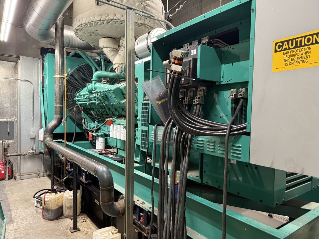 A teal standby generator in an indoor facility in Portland
