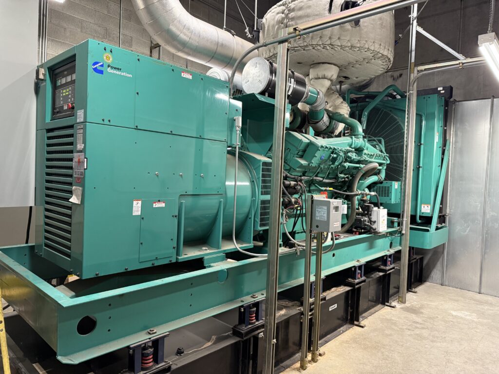 A teal Cummins standby generator in an indoor facility in Portland near Clackamas